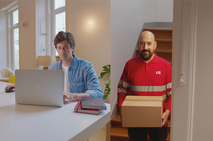Um homem sentado à secretária no computador e do lado direito um distribuidor dos CTT
